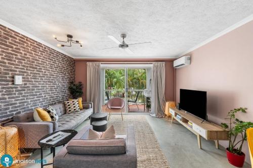 a living room with a brick wall at Burleigh Heads Koala Park Pool & Parking in Gold Coast