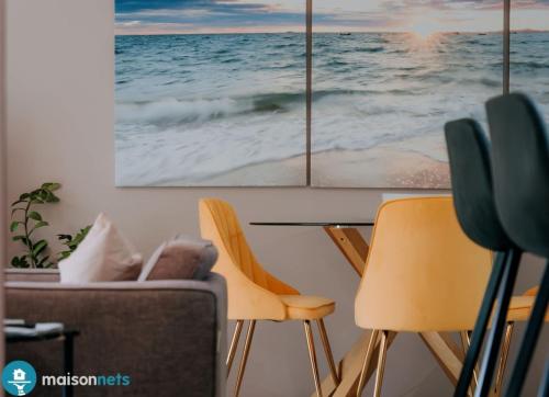 a dining room with chairs and a table with two paintings at Burleigh Heads Koala Park Pool & Parking in Gold Coast