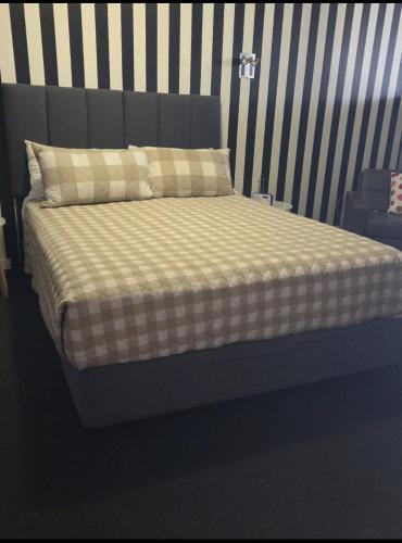 a bed with a checkered blanket and pillows on it at Yarrawonga Lakeside Apartment 31 in Mulwala