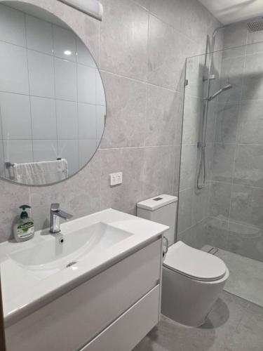 a bathroom with a sink and a toilet and a mirror at Yarrawonga Lakeside Apartment 31 in Mulwala