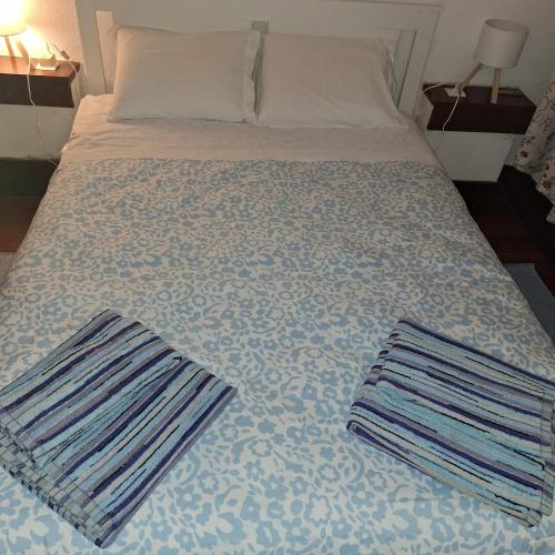 a bed with two towels on top of it at AL Tróia Penaferrim in Troia