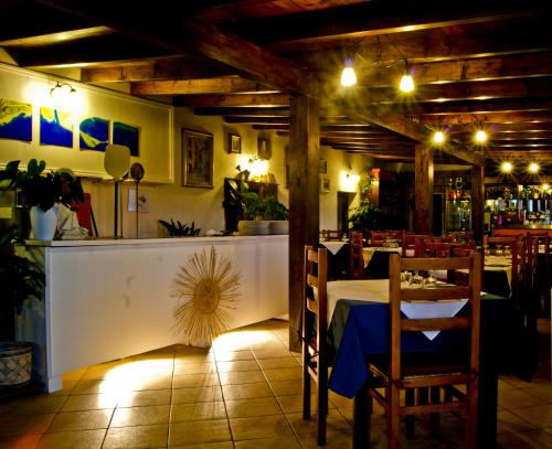 ein Esszimmer mit einem Tisch und einer Bar in der Unterkunft Hotel Miramare in Bosa Marina