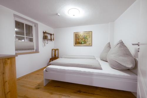 a bed in a room with white walls and a window at Modernes Altstadt-Juwel in Buchen