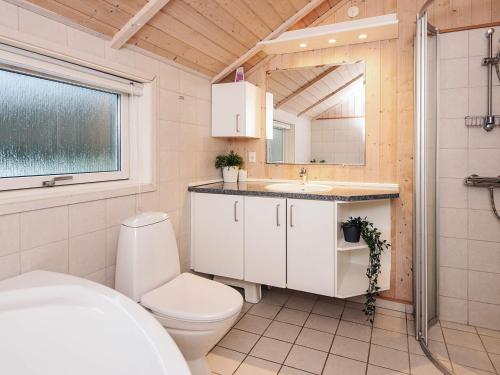 a bathroom with a toilet and a sink and a mirror at 6 person holiday home in Toftlund-By Traum in Toftlund