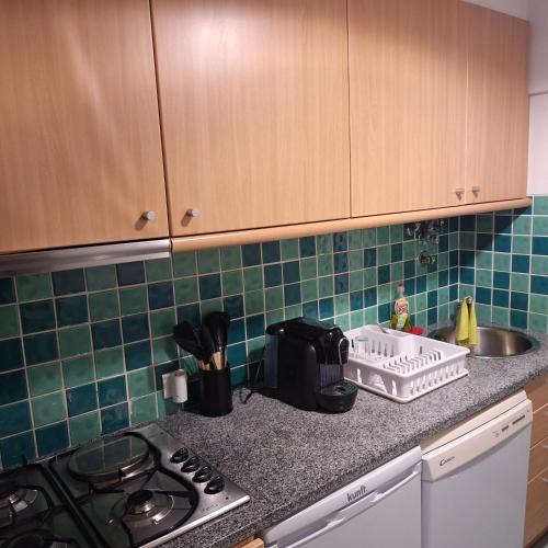 a kitchen counter with a stove and a sink at AL Tróia Penaferrim in Troia