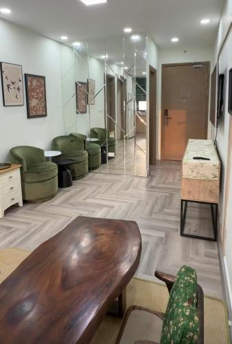 a lobby with a wooden table and green chairs at Niu Homestay in An Khê