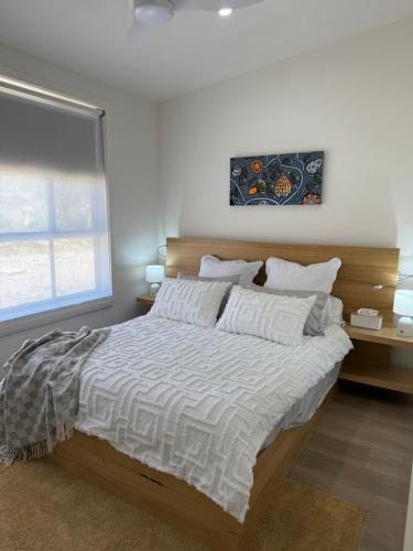 a bedroom with a large bed with a wooden headboard at Banksia apartment - Escape to Serene Rural Bliss! in Inverell