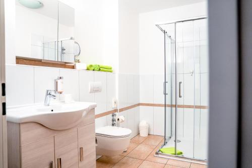 a bathroom with a toilet and a glass shower at Hotel ANNA - Düsseldorf - Hilden in Hilden