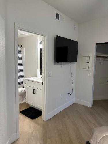 a white bathroom with a television on a wall at Home at Haven in Phoenix
