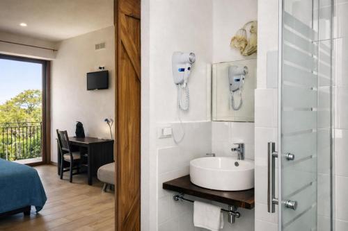a bathroom with a sink and a room with a bed at Residenza Cunto in Castellabate