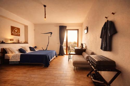 a bedroom with a bed and a couch and a window at Residenza Cunto in Castellabate