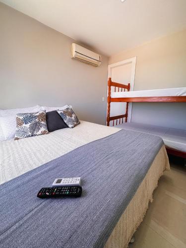 a remote control sitting on top of a bed at FLAT MANDAI Praia do Forte - Cabo Frio - RJ in Cabo Frio