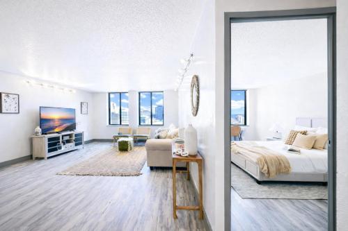 a white bedroom with a bed and a tv at The Hartford Skyline - Stylish Downtown Condo with Wifi Gym in Hartford