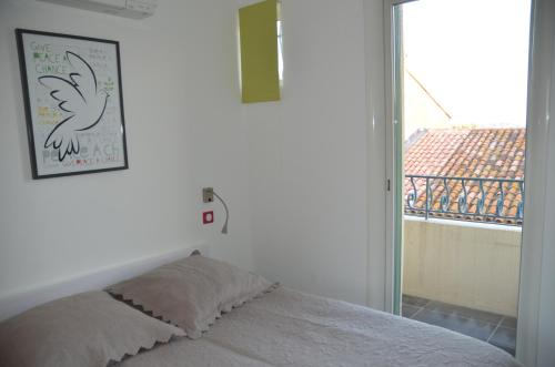 een slaapkamer met een bed en een raam met uitzicht bij L'excelsior in Bandol
