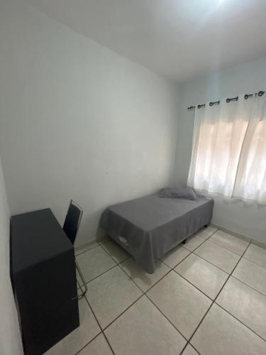 a small bedroom with a bed and a window at Casa BIG John 3 mato grosso in Divinópolis