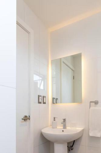 a white bathroom with a sink and a mirror at Studio Apartment Zona 10 near airport in Estación Pamplona