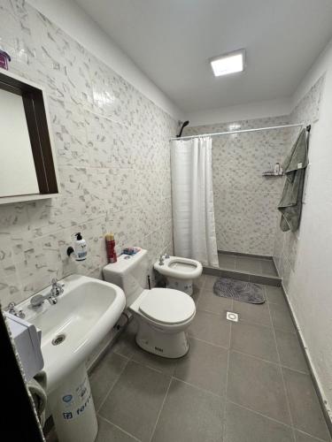 a bathroom with a white toilet and a sink at Loft Neuquén in Neuquén