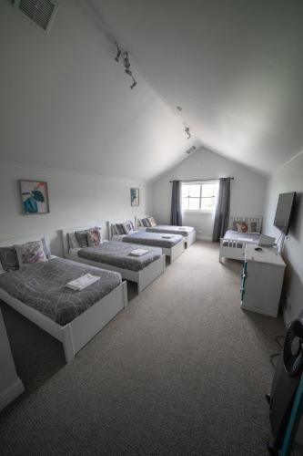 a room with four beds and a table in it at Terara Riverview Estate in Terara