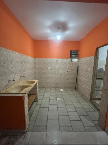 a bathroom with a sink and orange walls at Casa BIG John 4 Bahia in Divinópolis