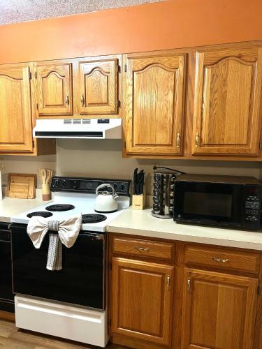 a kitchen with wooden cabinets and a black stove top oven at Comfortable 2BR-2BA Mountain Getaway Near Slopes in Cortland