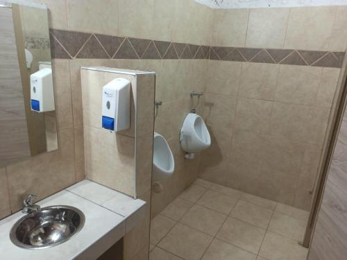 a bathroom with a sink and a urinal and a toilet at Alalá Campo in Pocito
