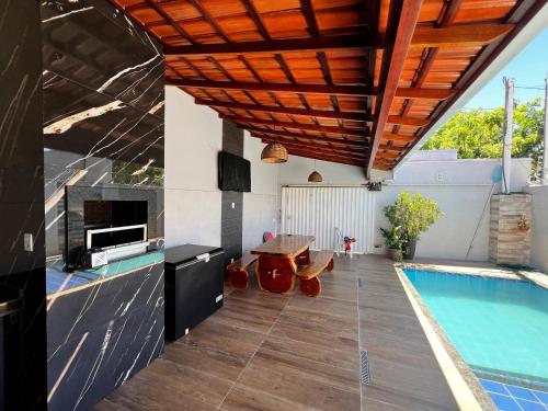 a patio with a swimming pool and a house at Casa inteira com Piscina - 3 Quartos - Área Gourmet - 5 min da Praia in Prado