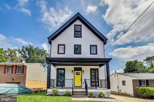 a white house with a yellow door at 35 Room 1 - 1 King Bed, Private Bathroom - Nonsmoking in Arlington