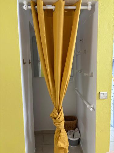 a curtain is tied up in a bathroom at Bungalow Cécilia in Petit-Bourg
