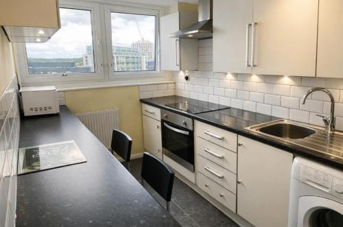 a kitchen with a sink and a stove top oven at City Centre 2 Bedrooms Apartments - Prime Location - next to Hilton Hotel - Victoria Centre Apartments in Victoria Centre Shopping Centre - 24 Hours Access - Parking Cars or Vans from Five Pounds a Day - Sunday 1pm Check-Out in Nottingham