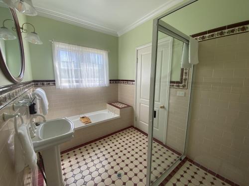 ein Badezimmer mit Badewanne, Waschbecken und Dusche in der Unterkunft Loggers Rest B&B in Stanthorpe