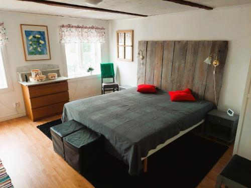 a bedroom with a large bed with red pillows on it at 4 star holiday home in ÖDESHÖG in Ödeshög
