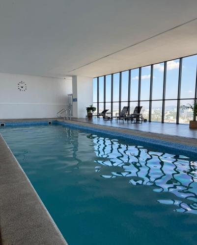 a swimming pool with blue water in a building at Departamento Prestigio 97 in Guadalajara