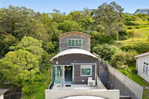 a house on the water with a boat at Comfort in Khandallah in Wellington