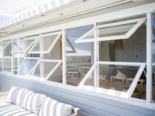 a screened porch with white windows and a couch at Walters in East Ballina