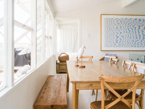 a dining room with a wooden table and chairs at Walters in East Ballina