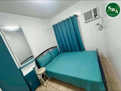 a hospital room with a blue bed and a window at JHS Condo in Davao City