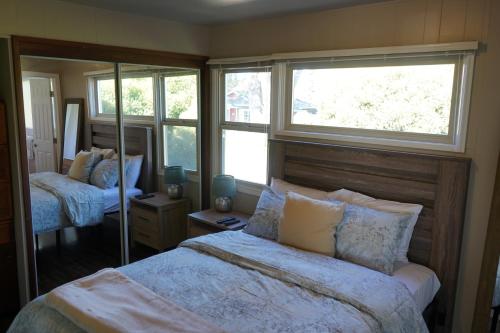 a bedroom with a large bed and a mirror at East Side Beach House in Santa Cruz