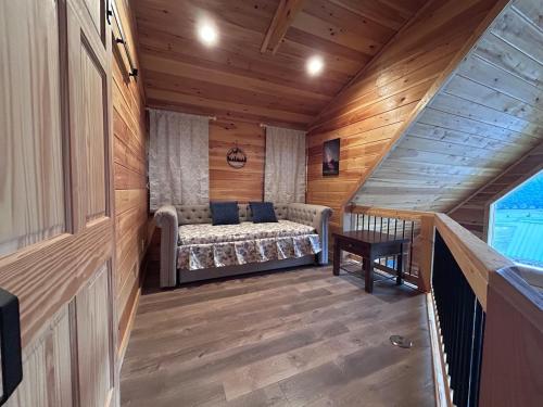 a room with a bed and a table in a cabin at Riverfront Blue Jay Cabin in Murphy