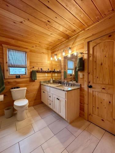 a wooden bathroom with a toilet and a sink at Riverfront Blue Jay Cabin in Murphy