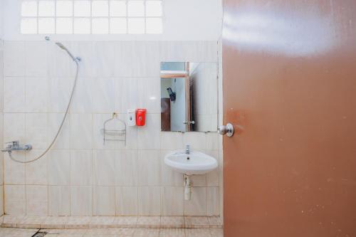 a bathroom with a sink and a shower at RedDoorz Plus at Amalio Hotel Surapati in Bandung