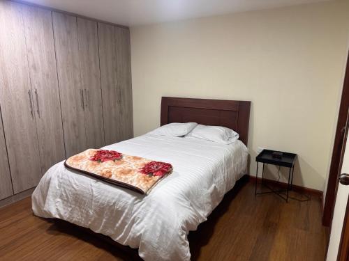 a bedroom with a bed with a tray with roses on it at Suite ejecutiva con Parqueo Privado in Latacunga