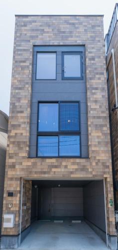 a brick building with four windows on it at Flower Base Botan in Fukuoka