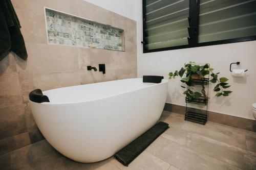 a large white bath tub in a bathroom at The Nest! in Cannonvale