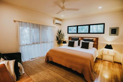 a bedroom with a large bed and a window at The Nest! in Cannonvale