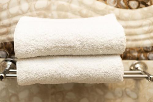 a stack of white towels on a towel rack at Museum Land Boutique Hotel in Cairo
