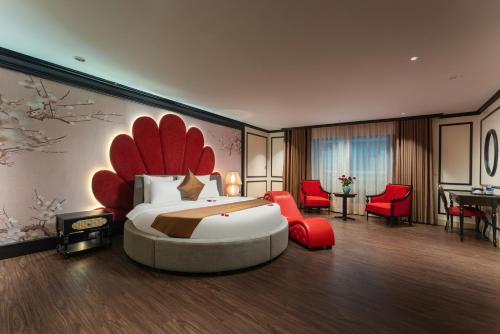 a bedroom with a large bed and red chairs at HALO HANOI HOTEL in Hanoi