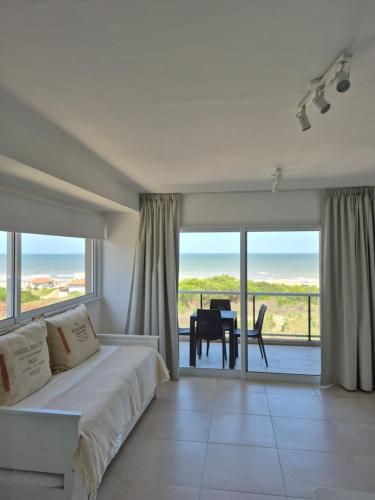 a bedroom with a bed and a view of the ocean at VIENTOS apartments in Villa Gesell