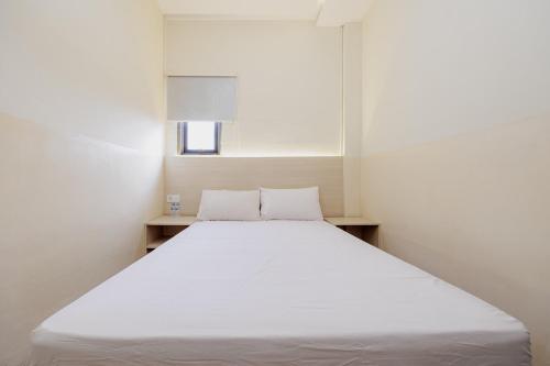 a white bed in a room with a window at Hotel C18 at Cibaduyut Mitra RedDoorz in Bandung