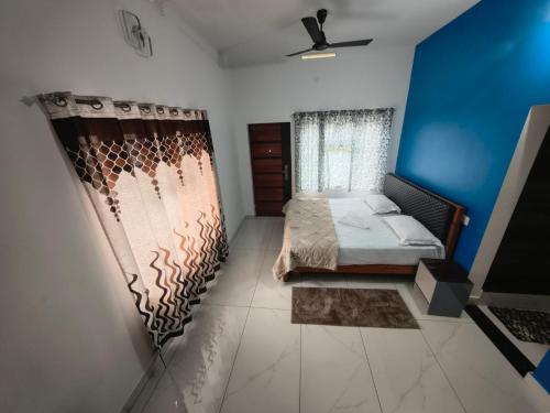 a bedroom with a bed and a window with a curtain at Bro Code Marayoor A Premium Family Friendly Retreat with Panoramic Mountain Views in Maraiyūr
