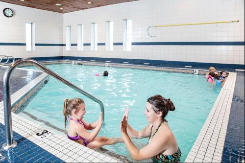 two girls sitting in a swimming pool at Radisson Hotel & Conference Centre Edmonton in Edmonton